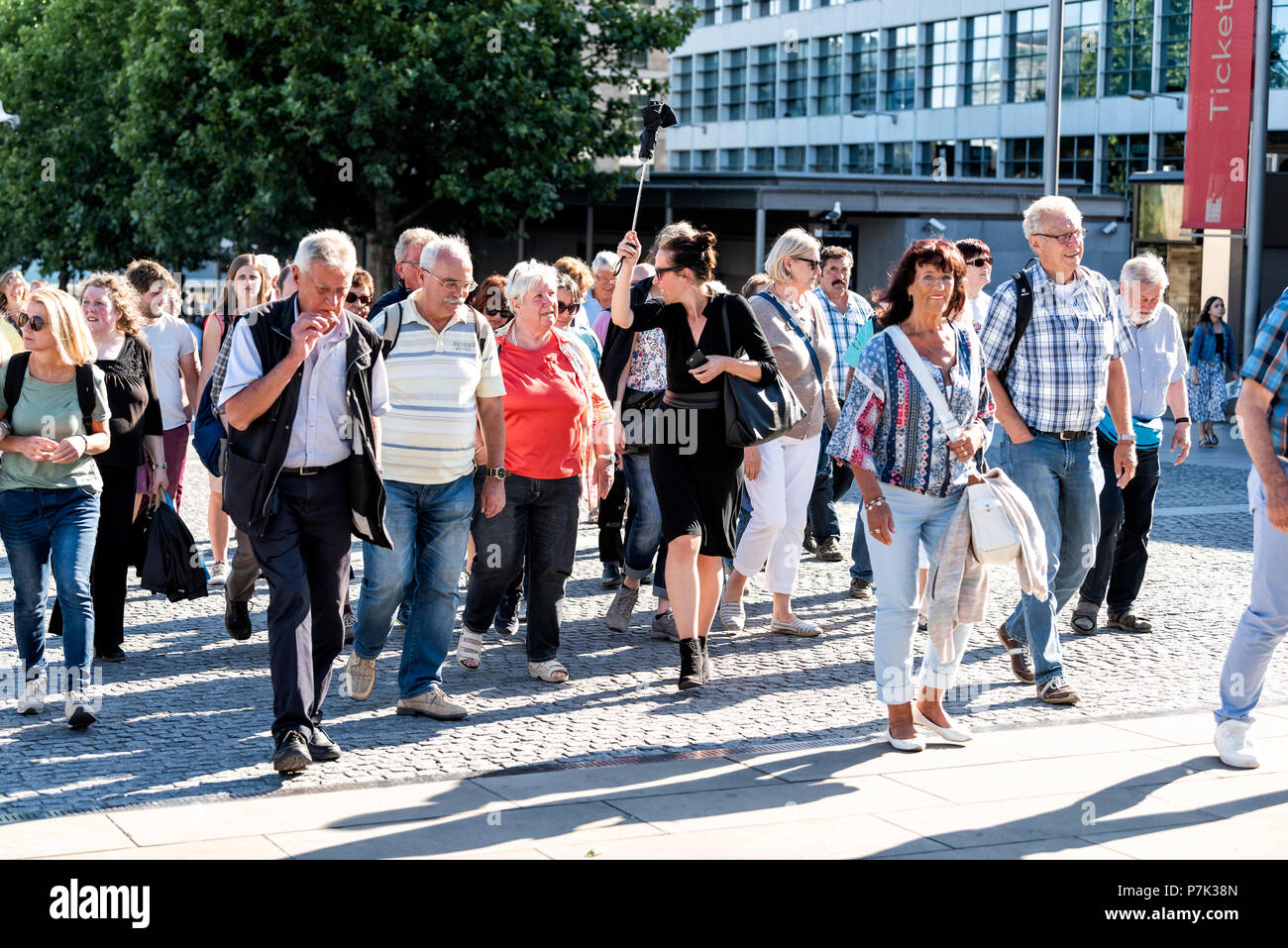 Londres, Royaume-Uni - 22 juin 2018 : foule de beaucoup de gens les piétons circulant sur un trottoir de la route de la rue par le Tower Bridge Pier, guide de visite femme carryi Banque D'Images