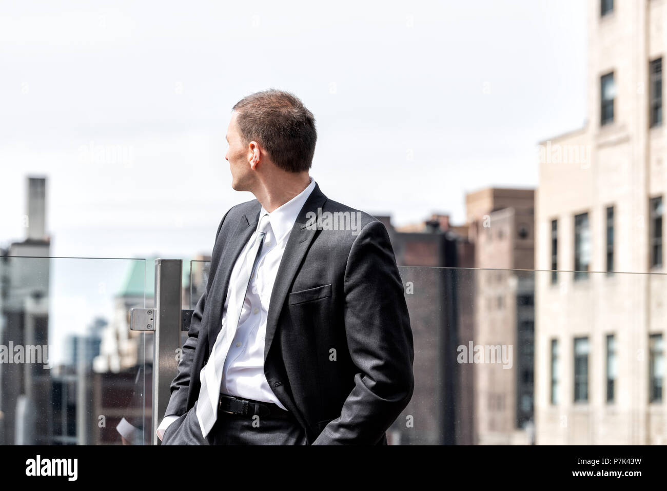 Young businessman standing in de costume d'affaires à New York Ville paysage urbain dans le centre de Manhattan skyline après entrevue pause à sky Banque D'Images