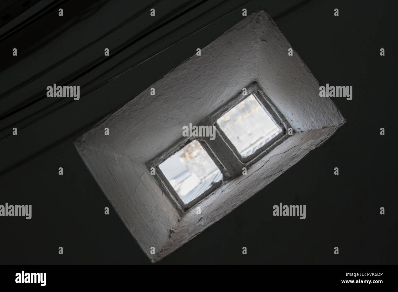 Une minuscule fenêtre faite de 2 briques de verre illumine l'air ambiant et des fils électriques qui passent. Pas de personnes. Le Brésil. L'Amérique du Sud. Banque D'Images