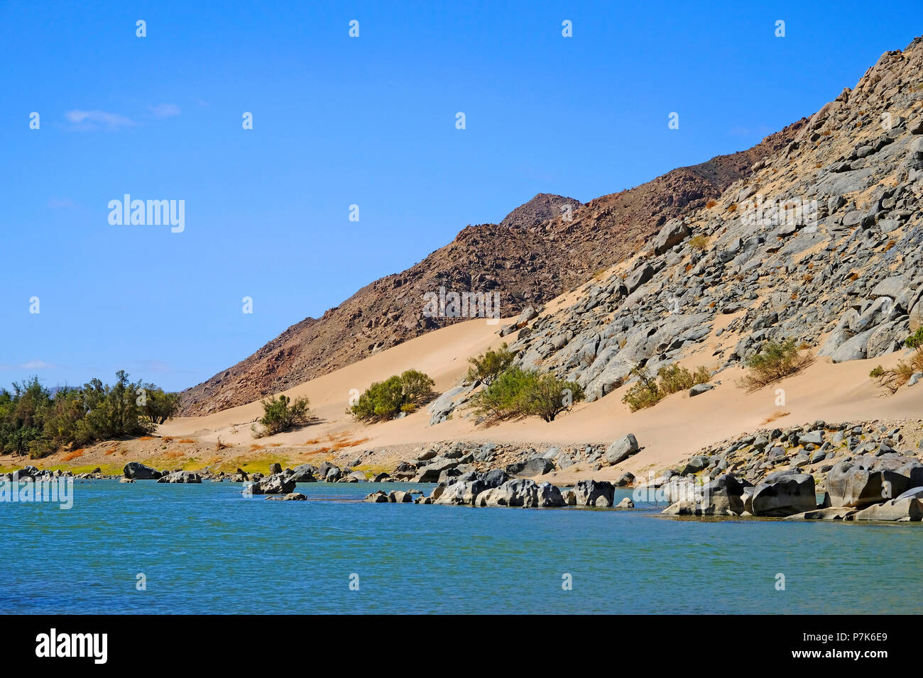 Stony pente rocheuse, avec du sable sur la dérive de l'Afrique du Sud de la rive du fleuve Orange / Oranjerivier (rivière frontière) entre la Namibie et l'Afrique du Sud, Namibie, Afrique du Sud, la Réserve Naturelle Aussenkehr Banque D'Images