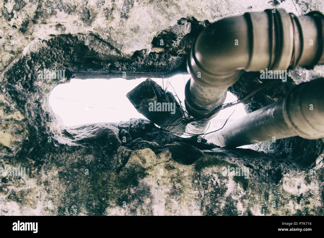 Énorme trou dans un mur fissuré est utilisé de passage de tuyaux d'eau dans un bâtiment utilisé comme slum condamné par le logement social mouvement. San Paolo. Le Brésil. Pas de p Banque D'Images