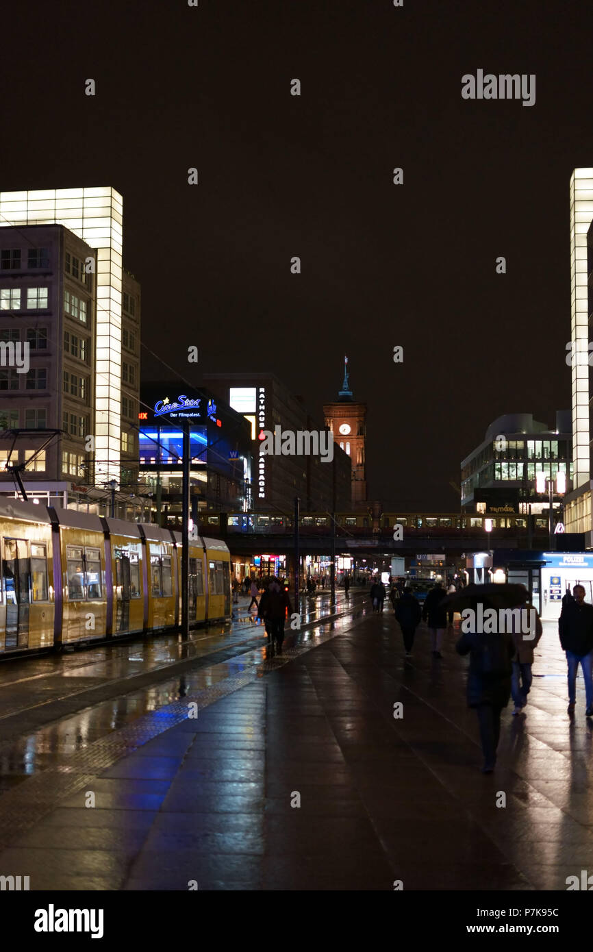 Un tramway à l'Alexanderplatz, la nuit sous la pluie avec magasins et le Rotes Rathaus en arrière-plan à Berlin, Banque D'Images