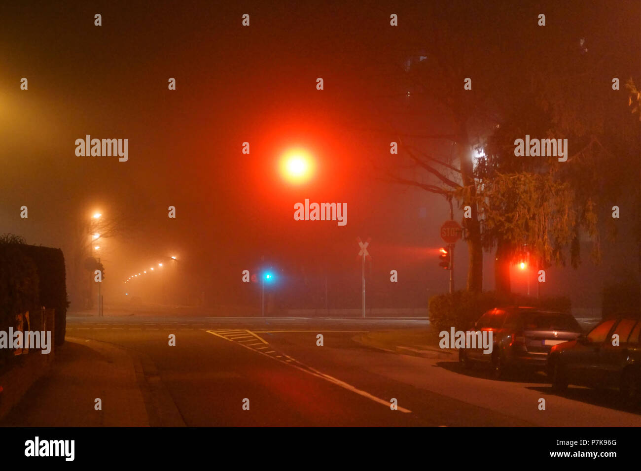 Une rue de lampadaires et d'un carrefour avec feu de signalisation dans la nuit et dans le brouillard, Banque D'Images