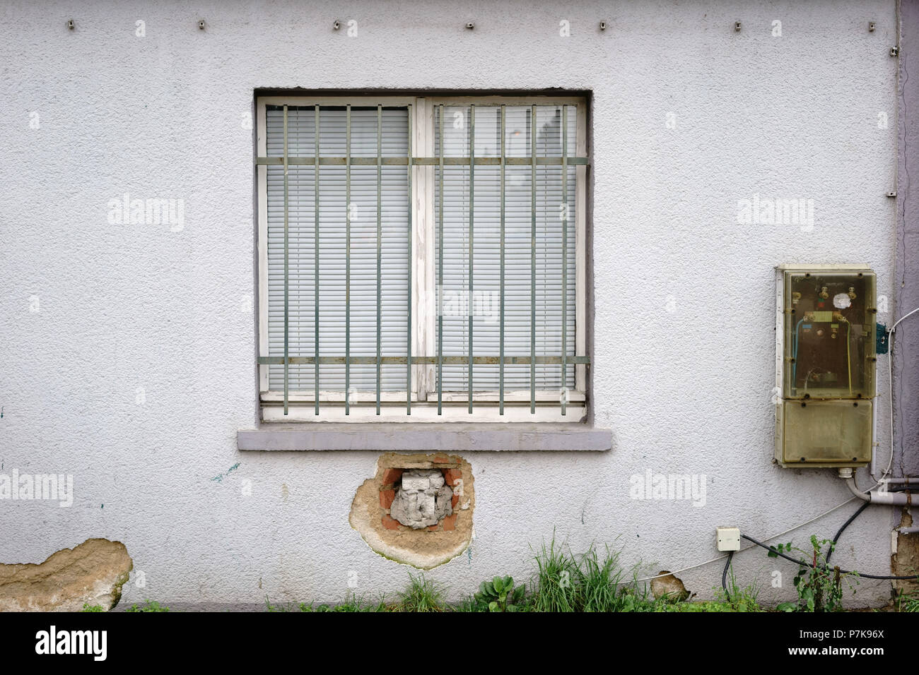 La fenêtre d'un immeuble délabré avec un ancien distributeur d'électricité, Banque D'Images