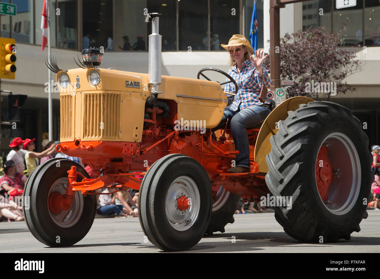 Femme conduit un tracteur d'époque au Calgary Stampede Parade. La parade dans le centre-ville fait chaque année le début du Stampede de Calgary. Rosanne Tackaberry/Alamy Live News Banque D'Images