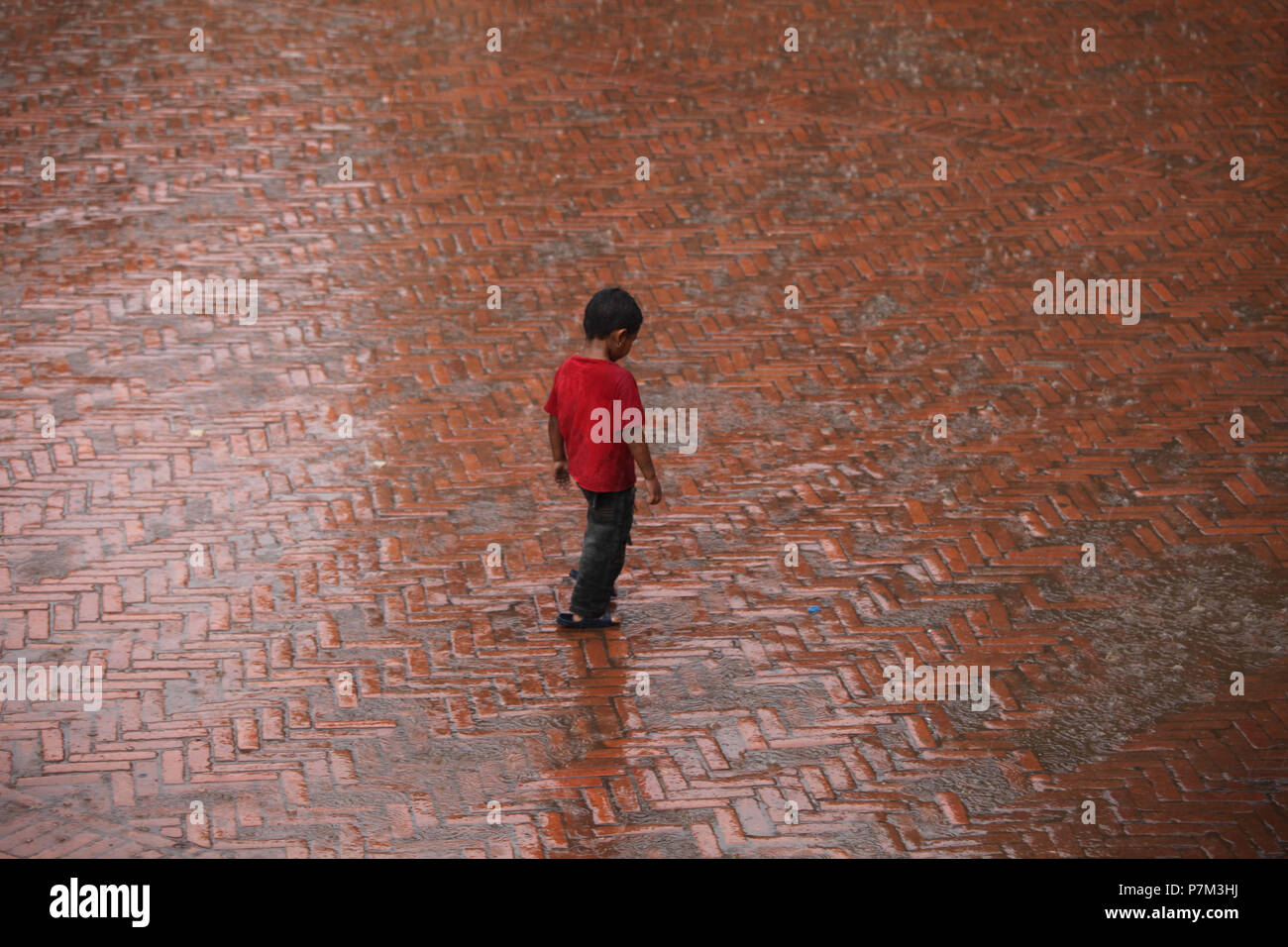Garçon sous la pluie, Katmandou, Népal Banque D'Images