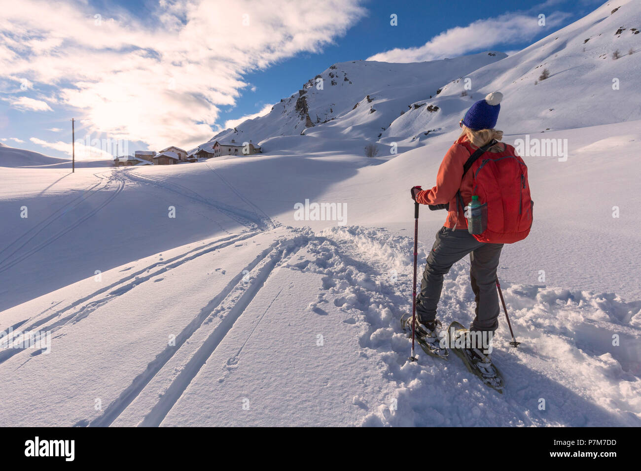 Jeune fille promenades en raquettes dans la neige fraîche au coucher du soleil. .Grevasalvas, vallée de l'Engadine, Grisons, Suisse, Europe. Banque D'Images