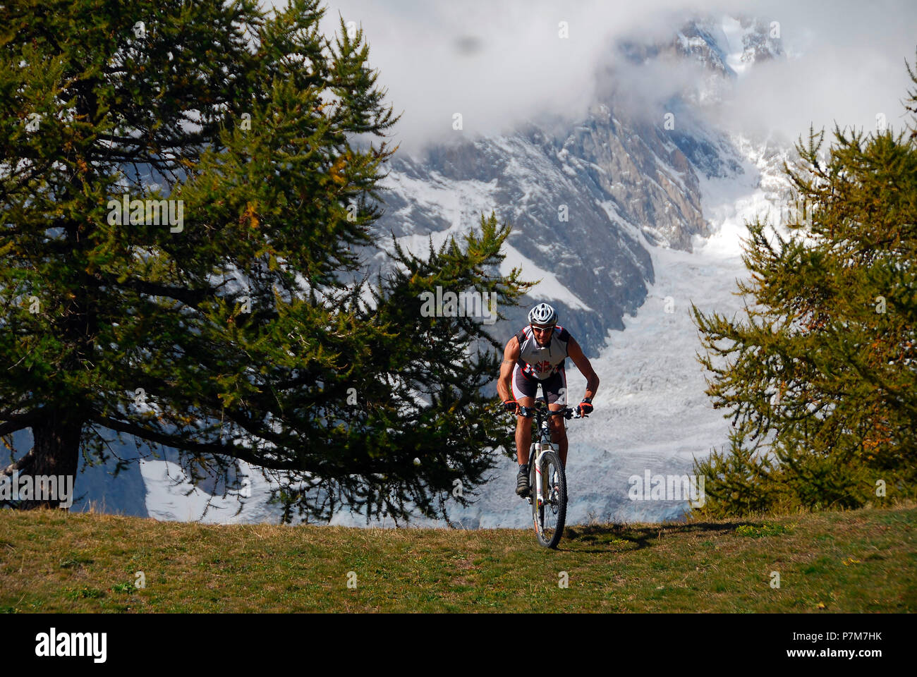 MTB Biker avec Glacier Brenva (mont Blanc) sur le contexte, Val Ferret, vallée d'aoste, Italie Banque D'Images