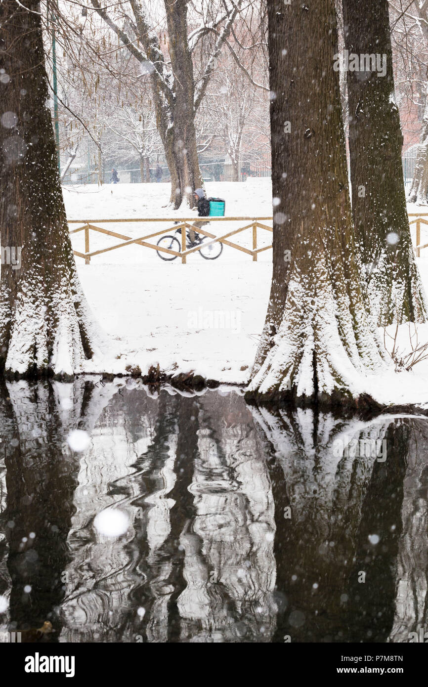 Le cycliste se promène dans le parc Sempione pendant une chute de neige, Milan, Lombardie, Italie du Nord, Italie, Banque D'Images