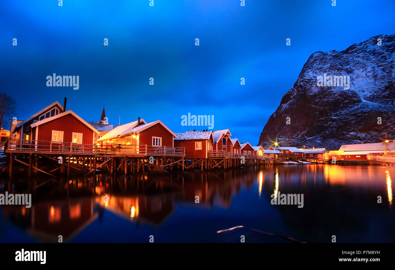 Maisons sur la mer de Norvège, à l'instar des échasses, reflétée sur la mer dans le port de Reine. Îles Lofoten Banque D'Images