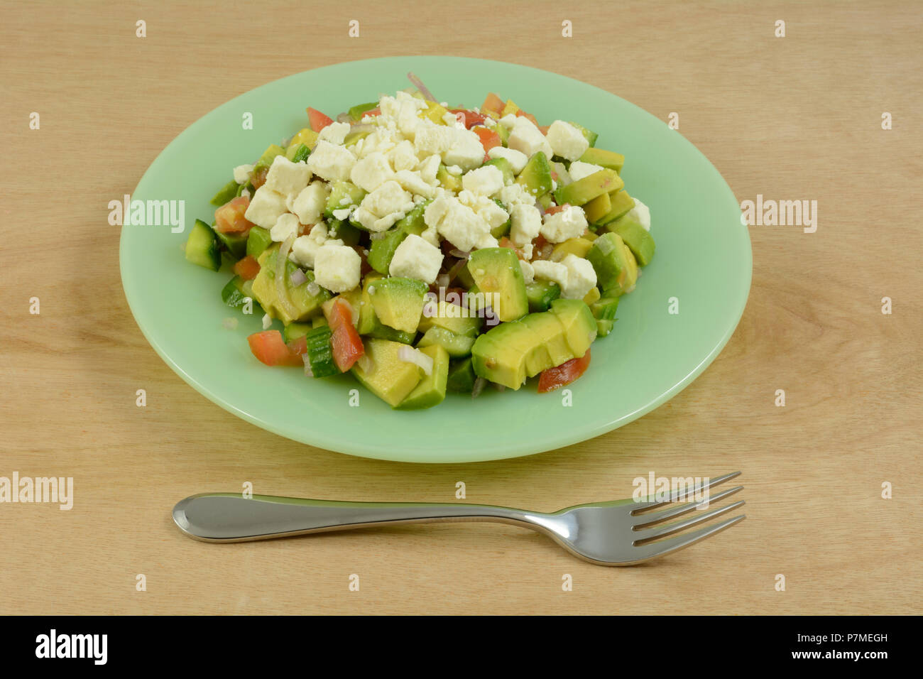 Salade de poulet à l'avocat, le concombre, la tomate et le fromage feta sur plaque verte avec la fourchette Banque D'Images