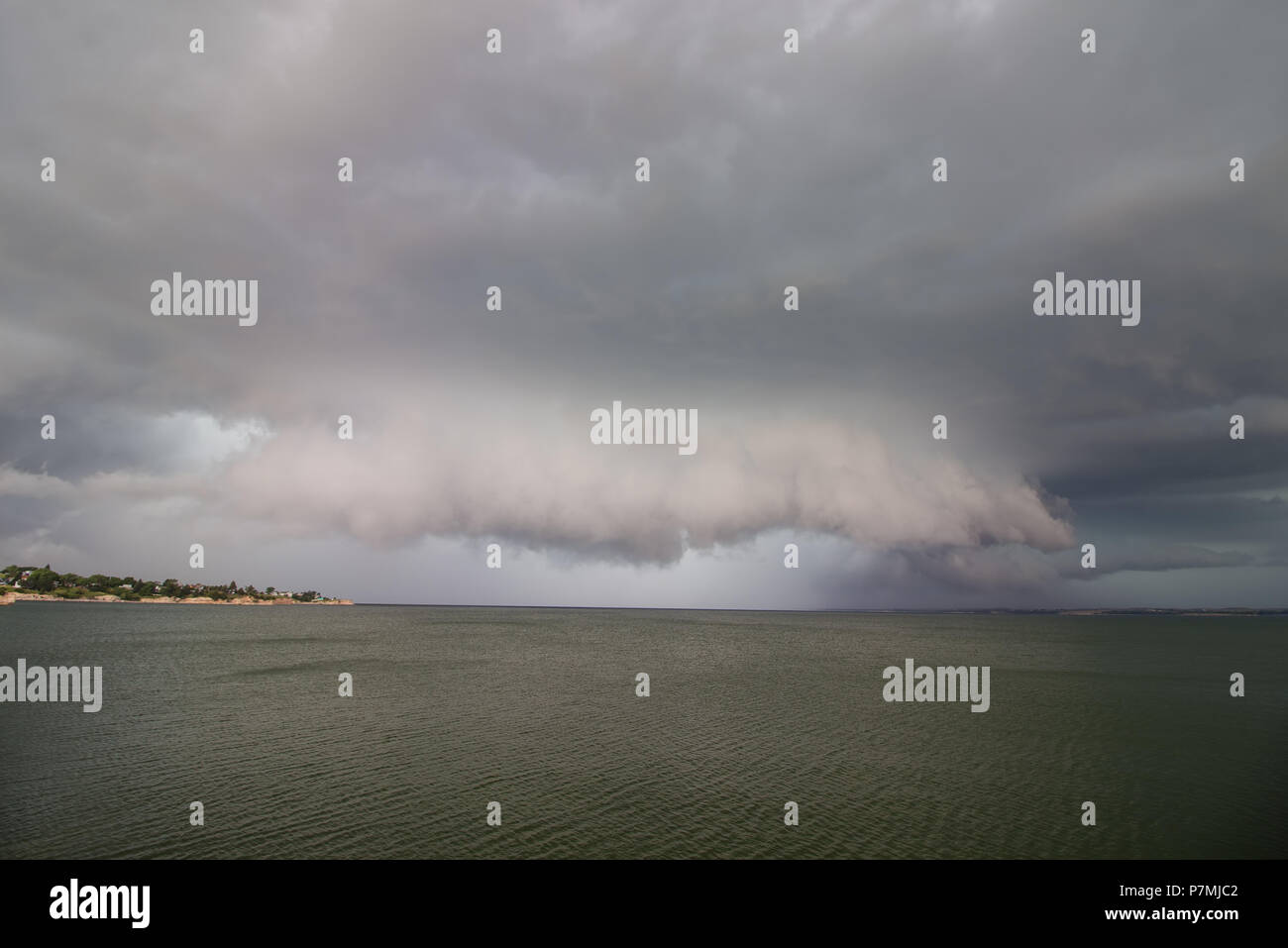 Un orage supercellulaire orage et mur de nuages plane sur un lac. Banque D'Images Un orage supercellulaire orage et mur de nuages plane sur un lac. Banque D'Images