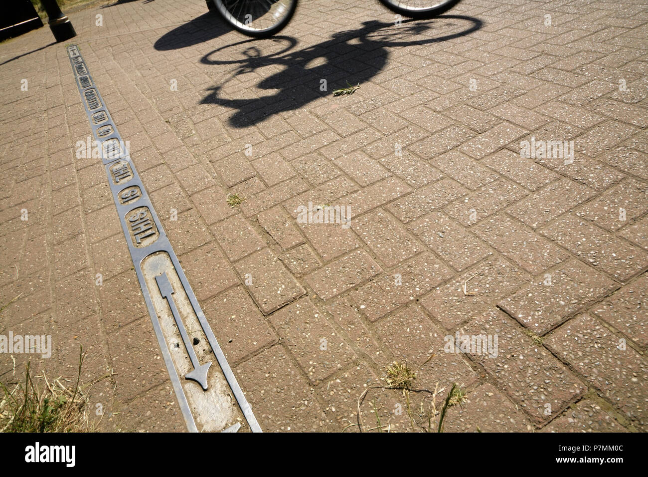 Cycliste passant la ligne du méridien de Greenwich, la longitude zéro Cleethorpes, Lincolnshire, Royaume-Uni. Banque D'Images