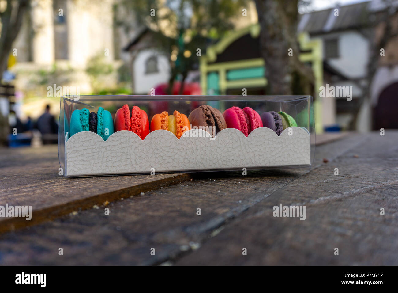 Belle boîte de macarons colorés sur un banc en bois au Festival du chocolat de Óbidos Banque D'Images Belle boîte de macarons colorés sur un banc en bois au Festival du chocolat de Óbidos Banque D'Images
