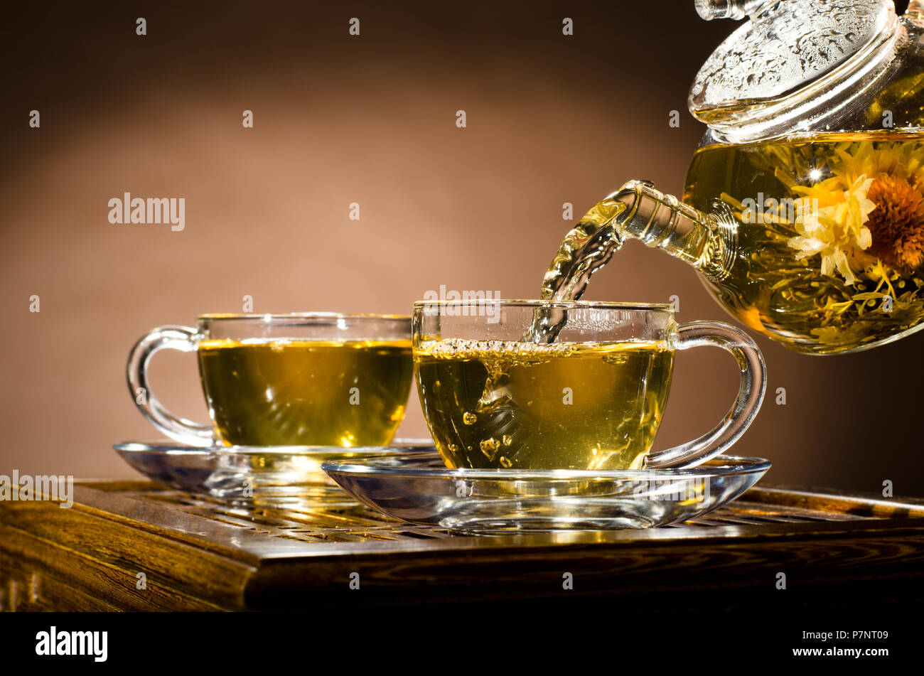 Photo horizontale, de la théière en verre tasse thé vert en débit sur fond brun, cérémonie du thé Banque D'Images