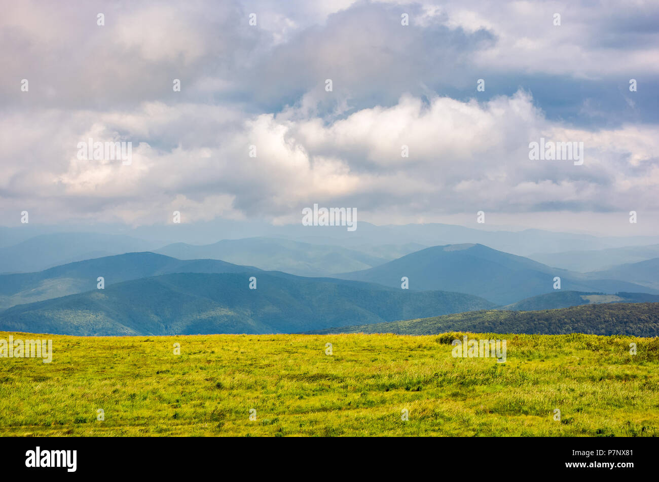 Herbacé pré alpin par temps nuageux. magnifique paysage de montagne des Carpates au loin. Superbe la formation de nuages au-dessus des minimums maison magnifique. Banque D'Images