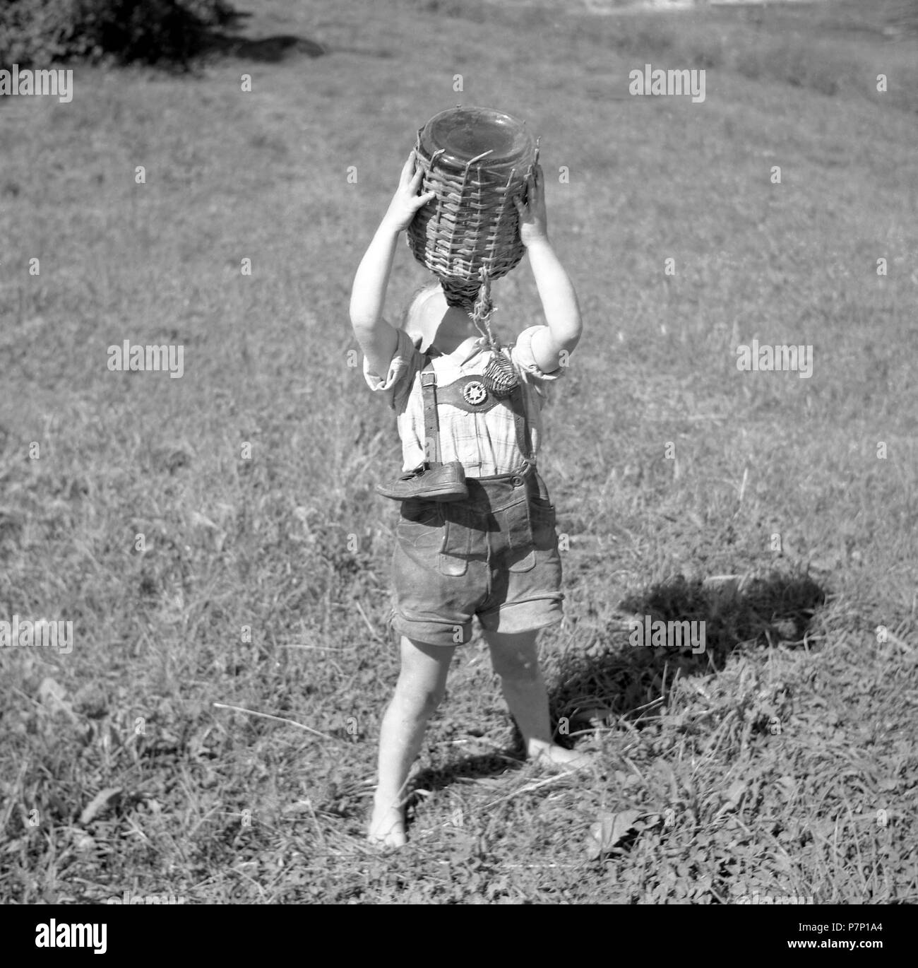 Enfant est pieds nus dans une prairie et des boissons de l'eau d'un sol en bois, bateau, ca. 1955, près de Fribourg, Allemagne Banque D'Images