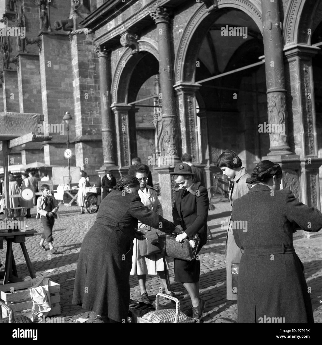 Le vendeur met quelque chose dans la poche du client, Freiburger Münstermarkt, autour de 1950, Freiburg, Allemagne Banque D'Images