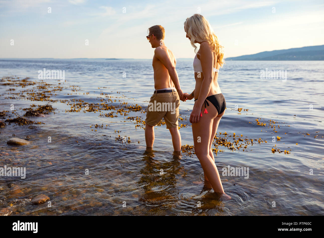 Couple holding hands et promenades au bord de la mer dans la soirée Banque D'Images
