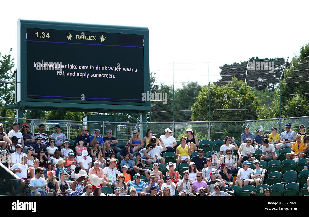 Un grand écran à lire 'par temps chaud prendre soin de boire de l'eau, porter un chapeau, et appliquez un écran solaire' sur trois de la Cour sur la sixième journée des championnats de Wimbledon à l'All England Lawn Tennis et croquet Club, Wimbledon. Banque D'Images