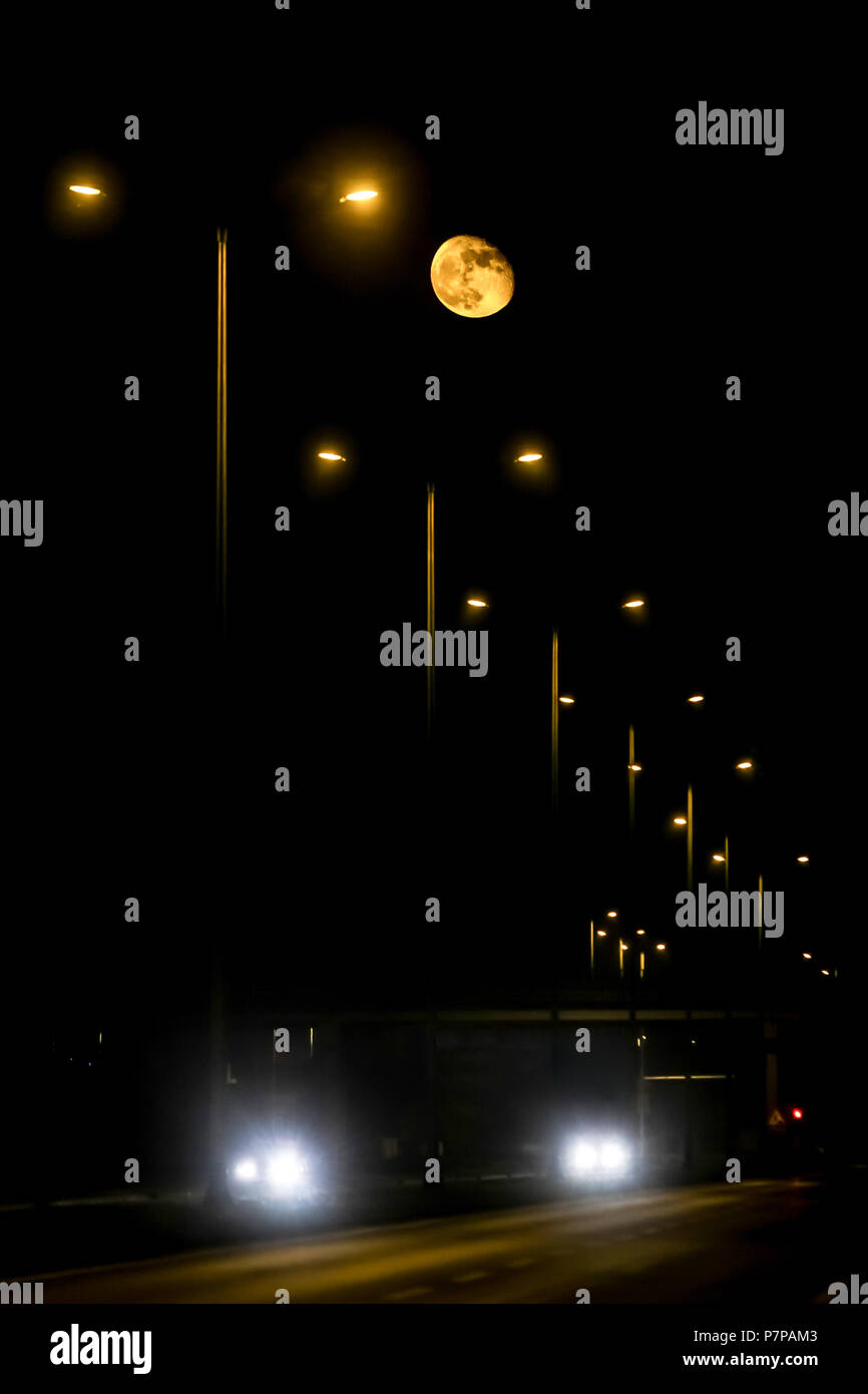 Vue de la pleine lune au-dessus de l'autoroute la nuit. Banque D'Images