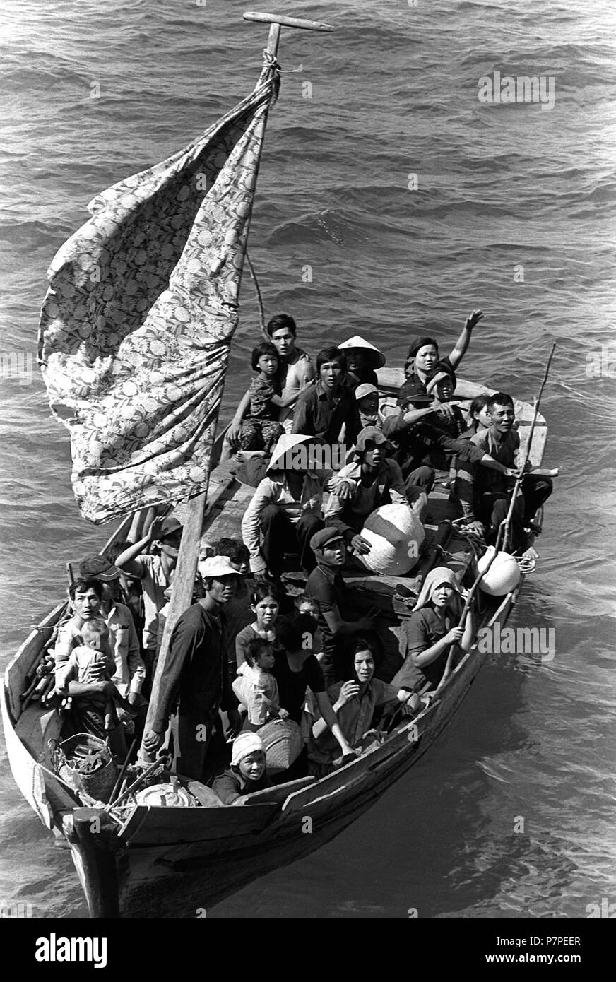 35 boat people vietnamiens 2. 35 réfugiés vietnamiens attendent d'être prises à bord du navire de commandement amphibie USS Blue Ridge (LCC-19). Ils sont secourus par un bateau de pêche de 35 pieds à 350 milles au nord-est de la baie de Cam Ranh, au Vietnam, après avoir passé huit jours en mer. Banque D'Images