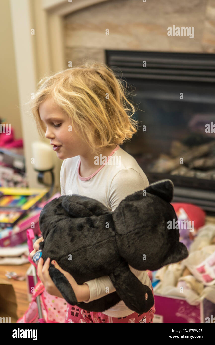 Jolie, 5 ans, fille blonde, jouant avec l'ours en peluche, Noël prewent. Cranbrook, BC, Canada. Parution du modèle # 113 Banque D'Images