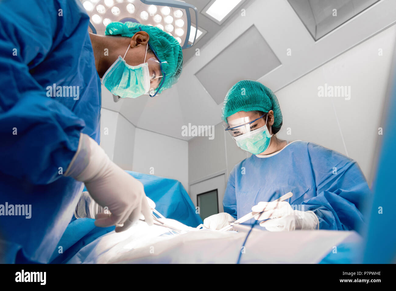 Les médecins et les infirmières avec des outils à mains rendant la chirurgie dans salle d'opération. Soins de santé et de l'hôpital concept Banque D'Images