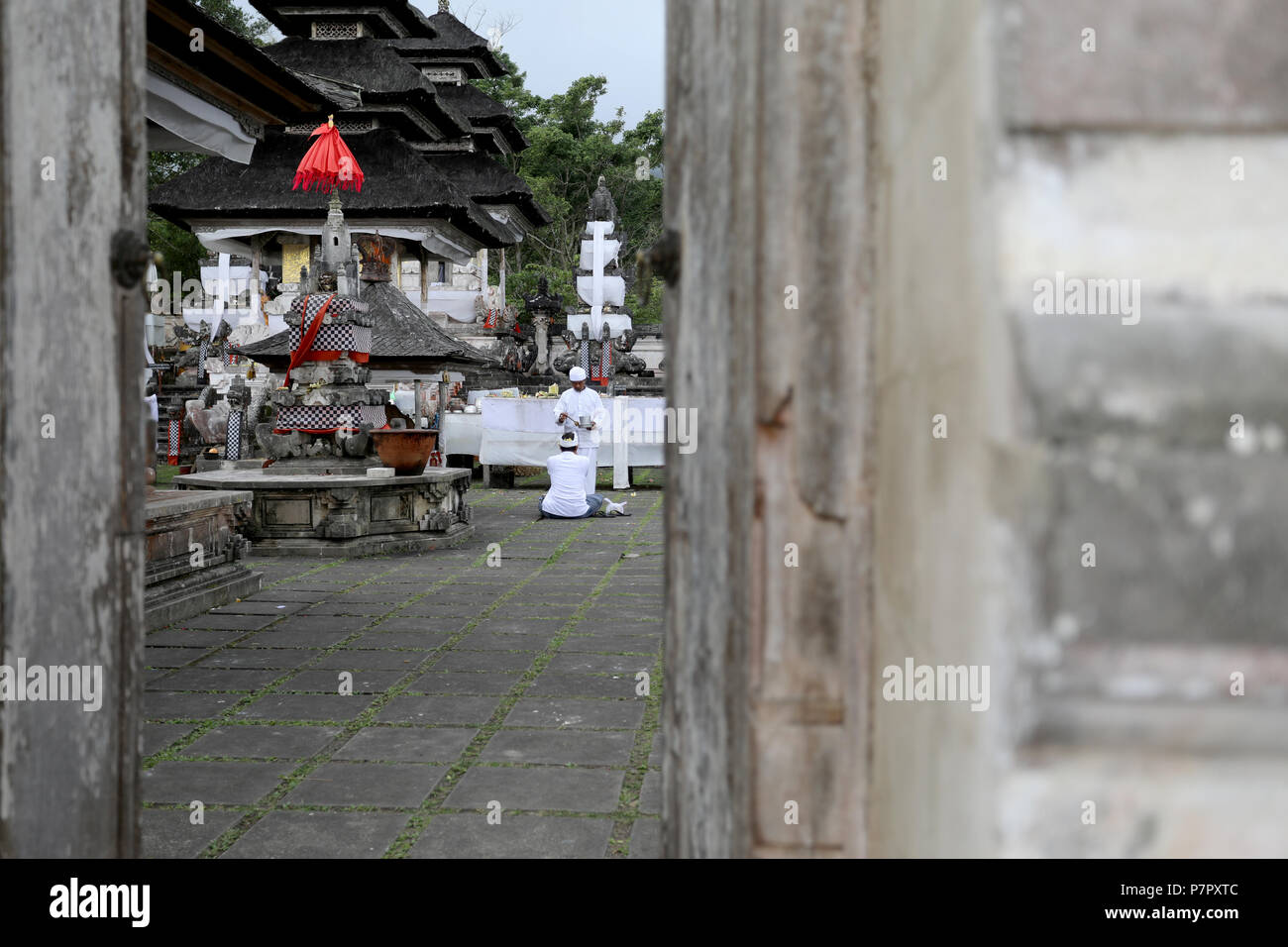 Amlapura, Indonésie - 5 juillet 2018 : un prêtre tend à un homme priant dans le temple de Lempuyang Luhur dans l'Est de Bali, Indonésie Banque D'Images