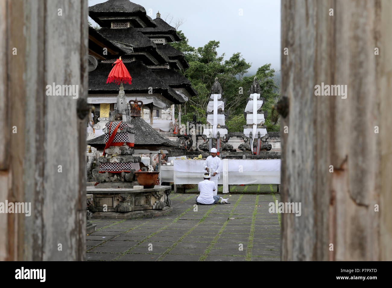Amlapura, Indonésie - 5 juillet 2018 : un prêtre tend à un homme priant dans le temple de Lempuyang Luhur dans l'Est de Bali, Indonésie Banque D'Images