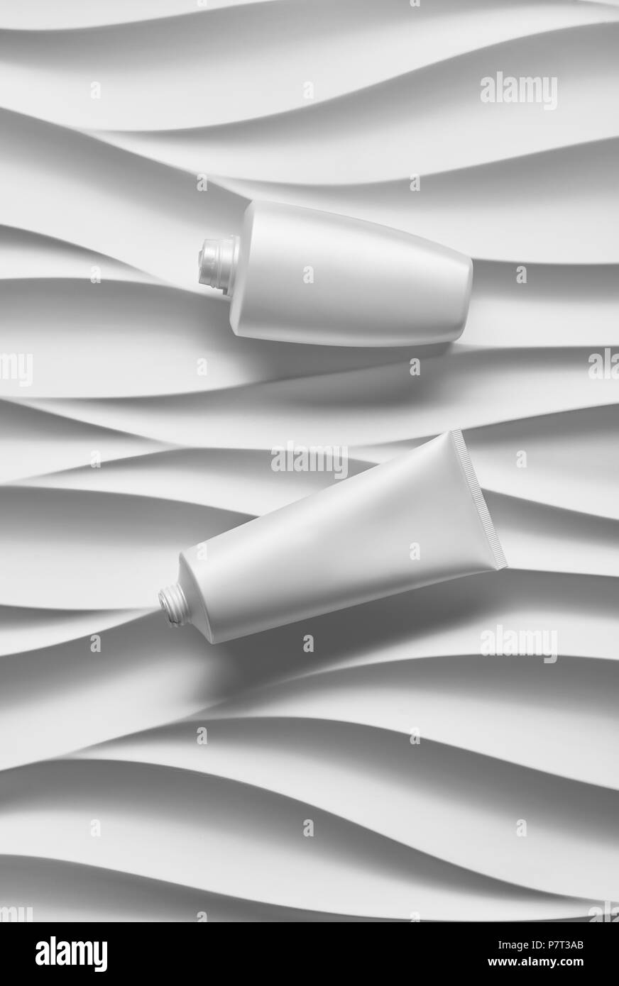 Belle affiche de format avec des vagues gris fond abstrait avec tonalités grisâtre, avec des contenants de plastique blanc propre : pot de crème, bouteilles, t Banque D'Images