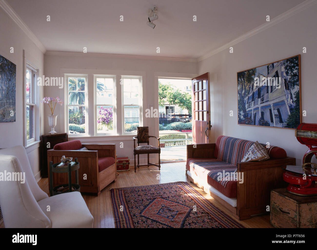 Cadre en bois, canapé et fauteuil de salon californien blanc extension avec  tapis à motifs et porte ouverte Photo Stock - Alamy