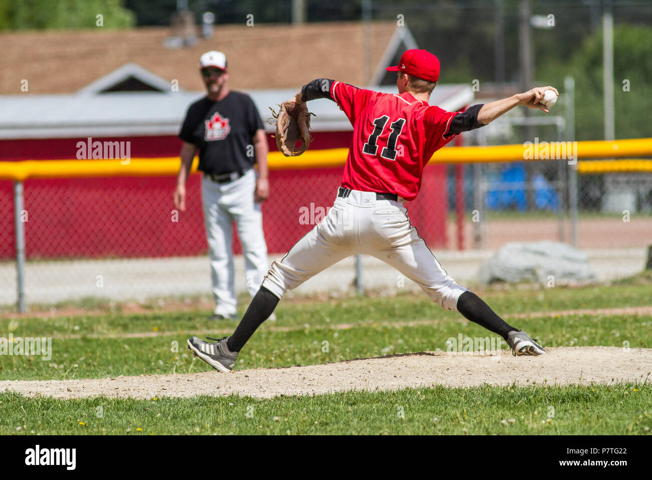 La prestation de Pitcher la hauteur, en pleine course, montrant l'adhérence. Baseball senior garçons. Cranbrook, BC. Banque D'Images