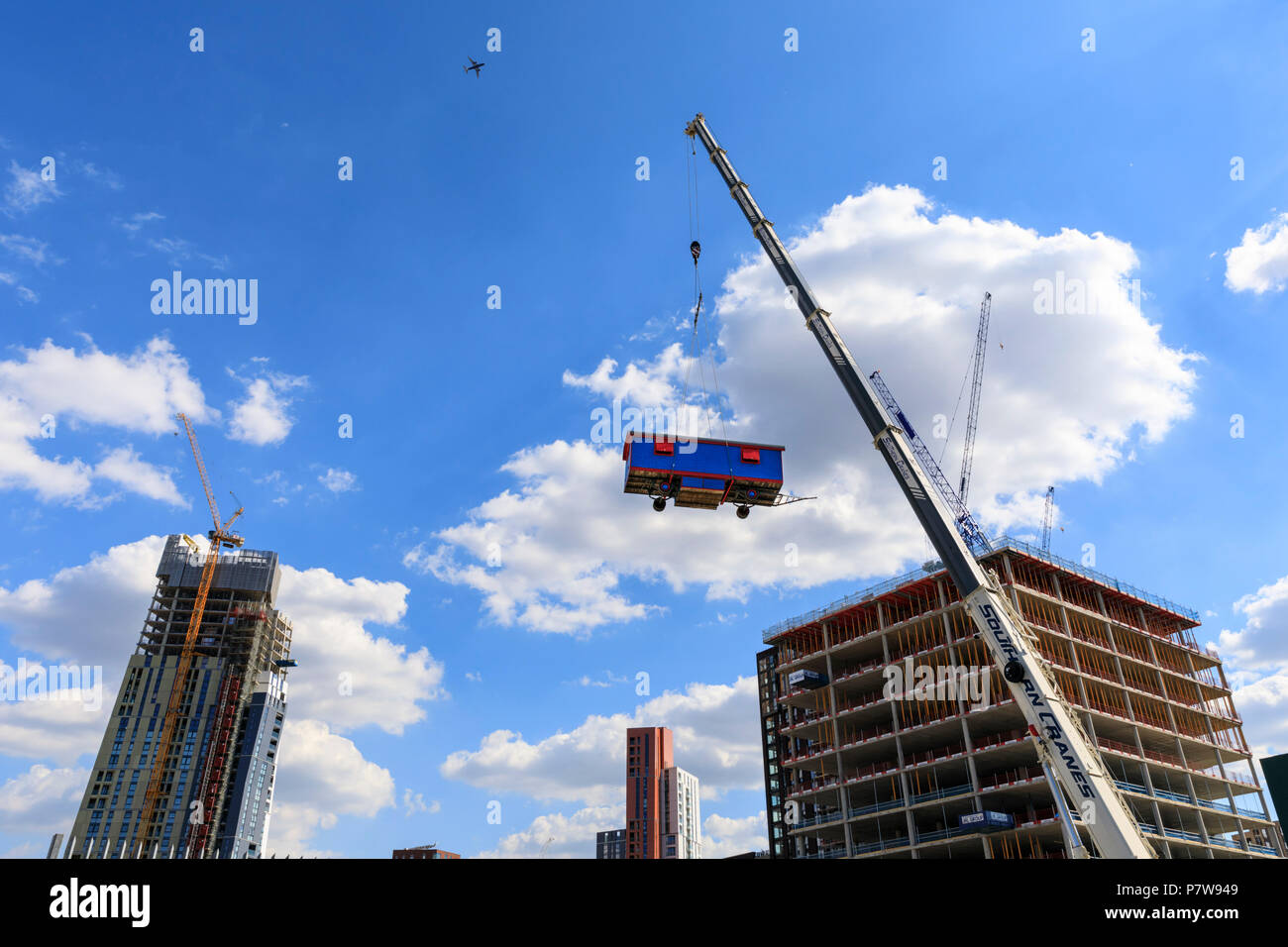 Londres, Royaume-Uni. 8e juillet 2018. Lara Favaretto spectaculaire de l'installation 'i poveri sono matti' (les pauvres sont fous) dispose d'une caravane bleu et rouge suspendue à 30 mètres en l'air à une grue à Nine Elms. Nuit de l'Art 2018 dispose de 12 projets spéciaux organisée par la Hayward Gallery et plus de 50 présenté dans l'Art nuit ouverte organisée par les organismes culturels et créatifs tout au long de South Bank, Vauxhall et neuf Elms, le samedi 7 et dimanche 8 juillet. Credit : Imageplotter News et Sports/Alamy Live News Banque D'Images