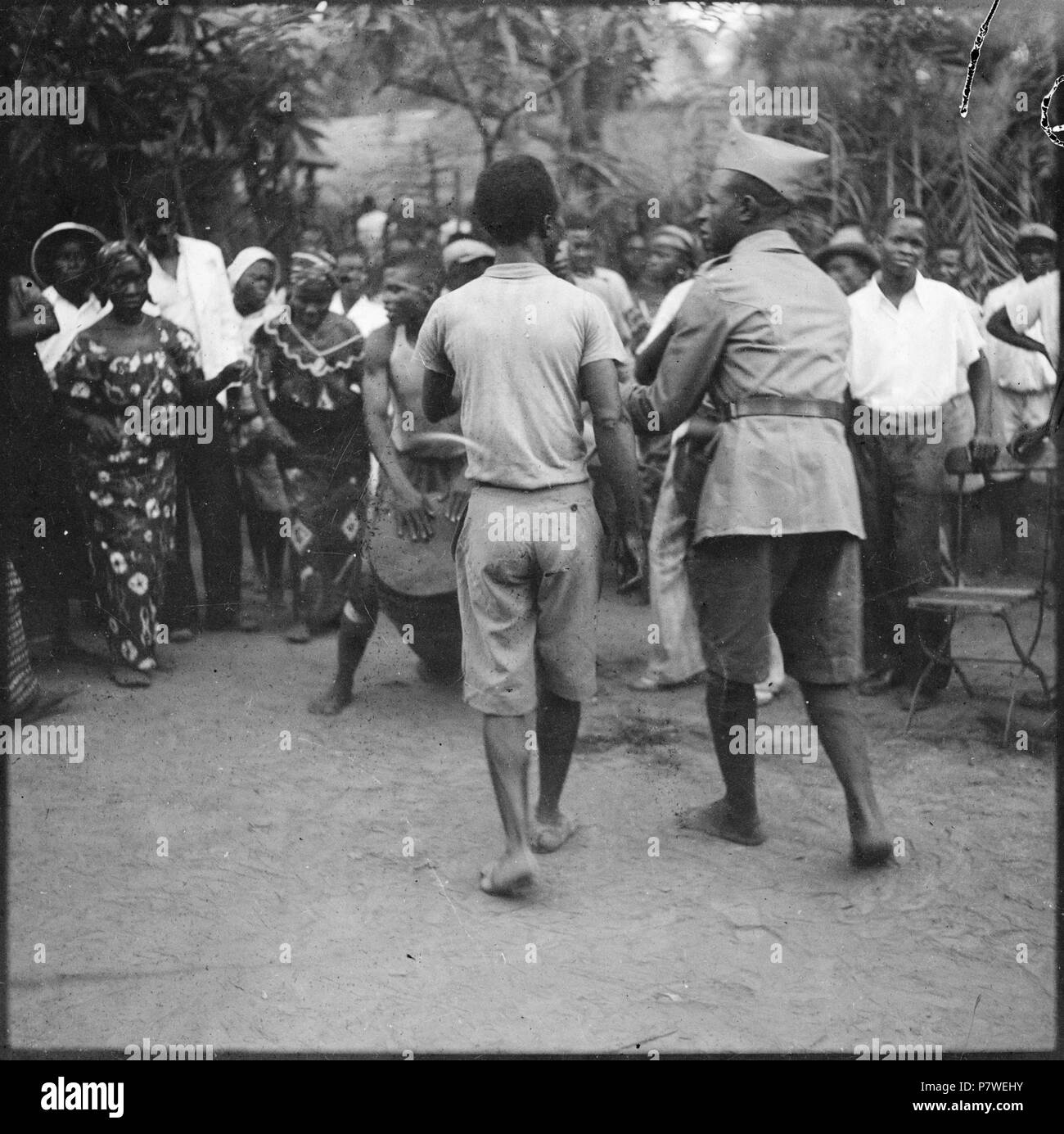 Belgisch-Kongo, Léopoldville (Kinshasa) : Strassenszene ; Gruppe von Personen auf einer Strasse der Kreis und bildet tanzt zu des Trommelklängen uniformierter Tam-Tam, darunter ein Polizist. de mai 1941 à mars 1942 66 CH-NB - Belgisch-Kongo, Léopoldville (Kinshasa)- Strassenszene - Annemarie Schwarzenbach - SLA-Schwarzenbach-A-5-26-005 Banque D'Images