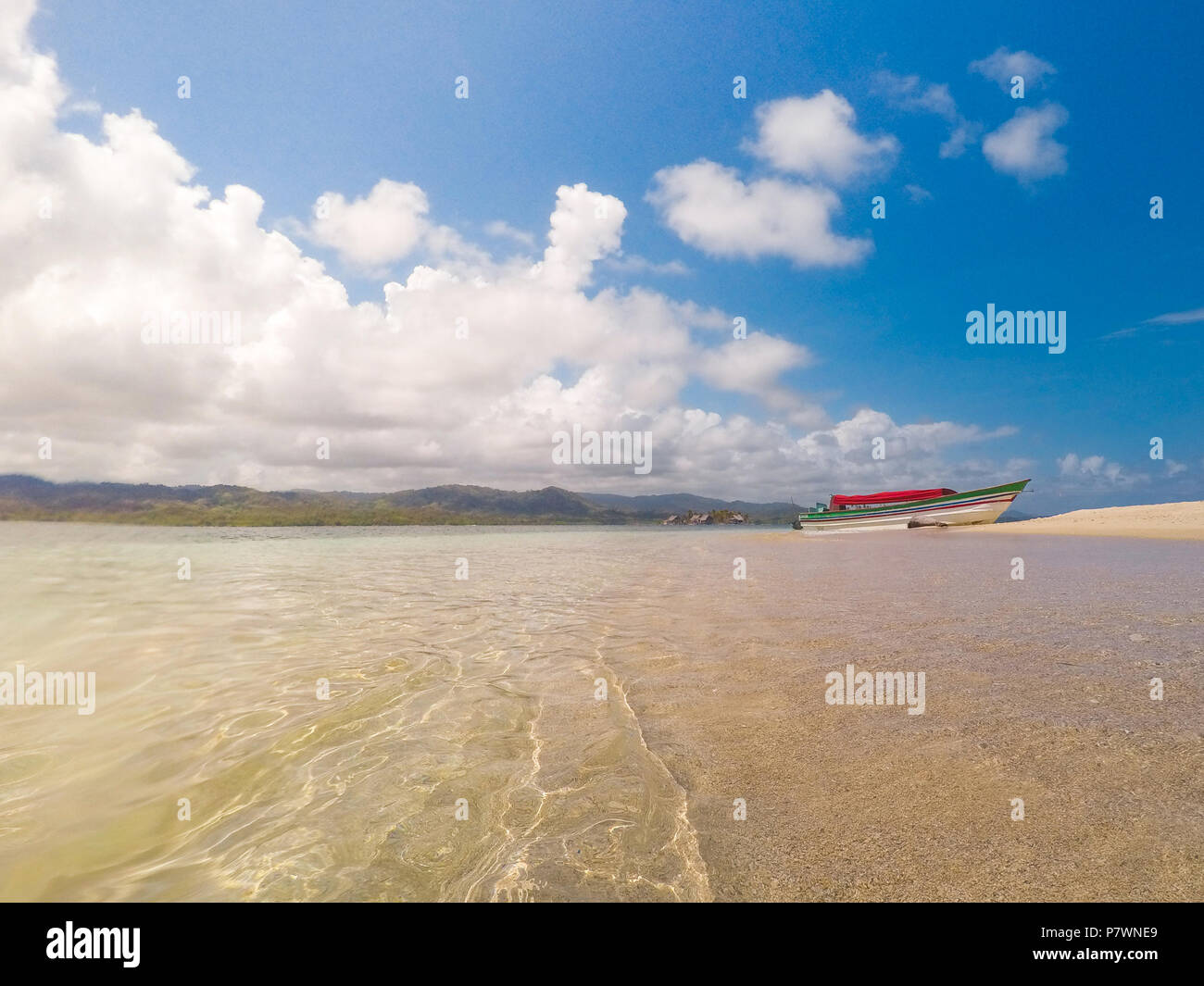 L'eau de mer et plage de sable à gros plan avec voile en arrière-plan Banque D'Images