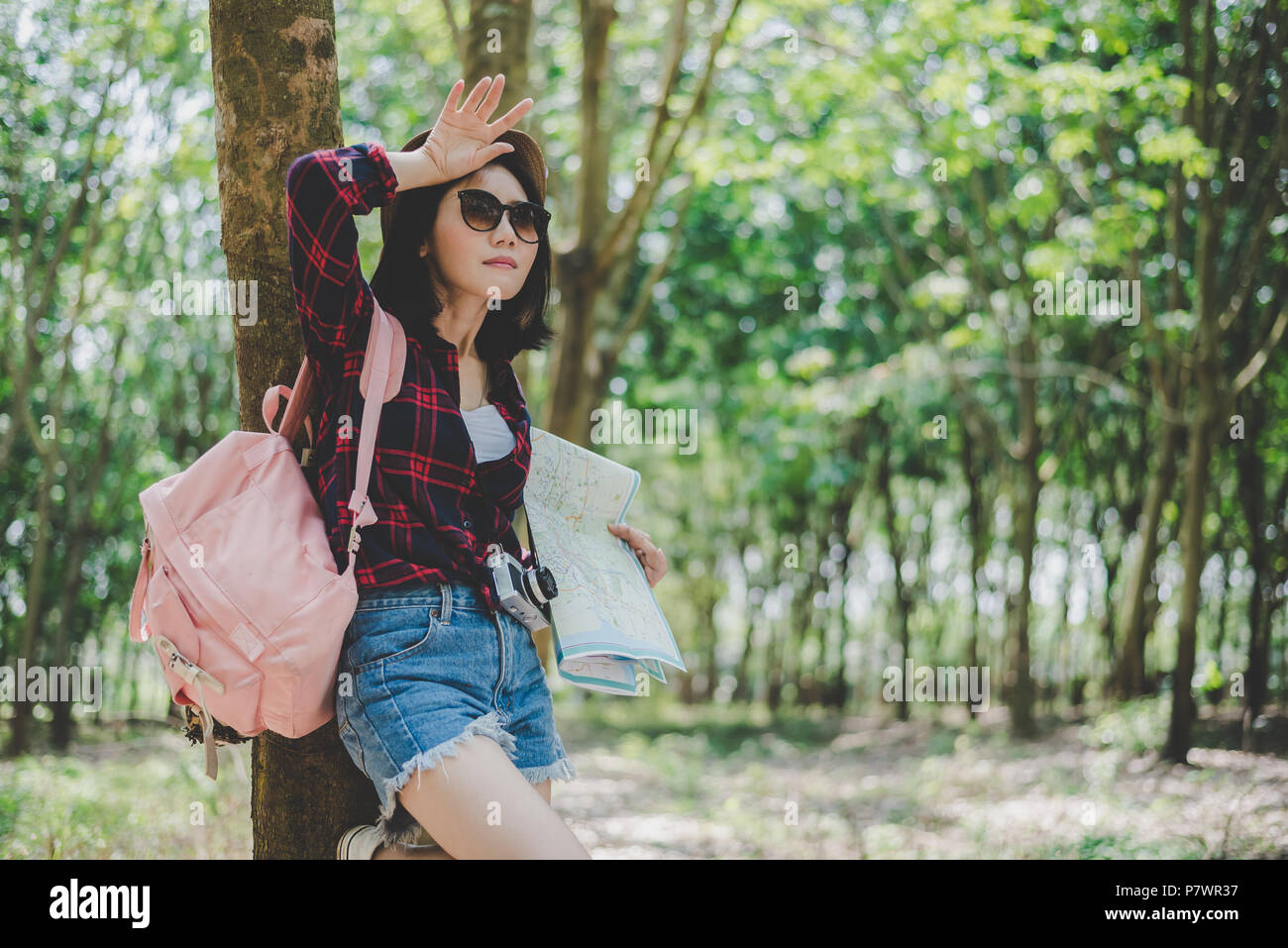 Asian female traveler fatiguant de perdu son chemin dans la forêt. Femme essuyant la sueur à la main. Fille soloe voyages et de l'aventure concept. Portrait et Li Banque D'Images