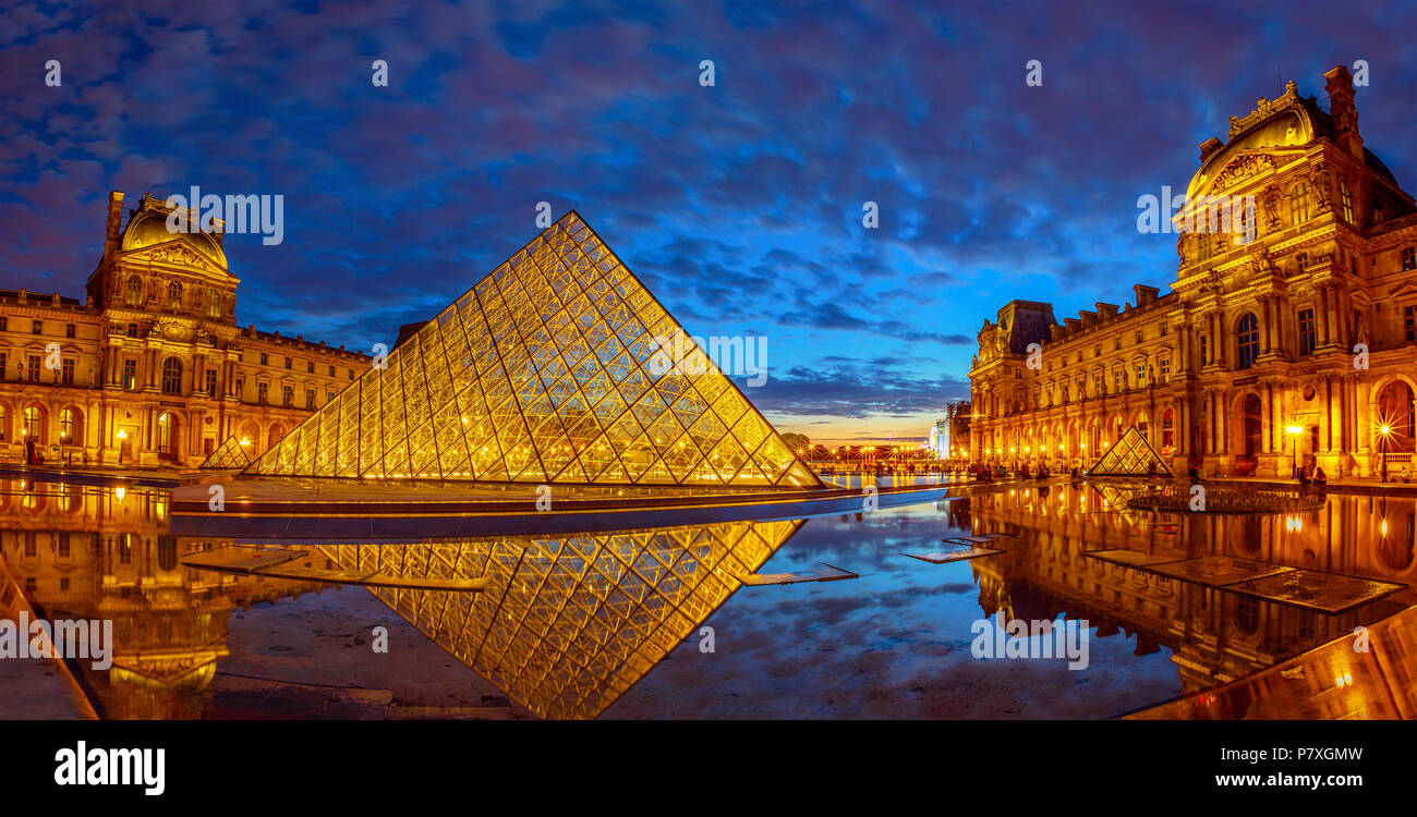 Paris, France - 1 juillet 2017 : panorama de la Cour Napoléon du Musée du Louvre à l'heure bleue. Pyramide de verre et Pavillon Rishelieu en miroir dans une piscine au crépuscule. Palais du Louvre est un célèbre monument de Paris Banque D'Images