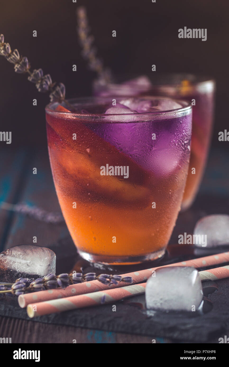 Peach aperol spritz avec tranches de pêches et de l'eau de lavande sur un bureau en bois. Banque D'Images