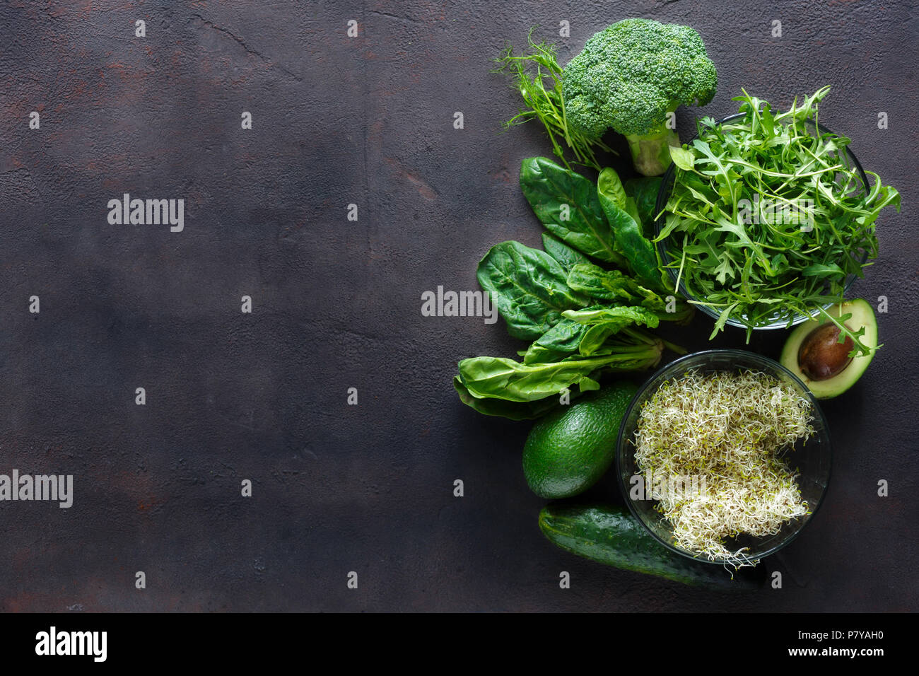 Ensemble d'ingrédients pour salade detox sur fond foncé avec bordure. Le brocoli, épinards, avocat, roquette, pousses de pois, luzerne et de concombre sur dark backg Banque D'Images