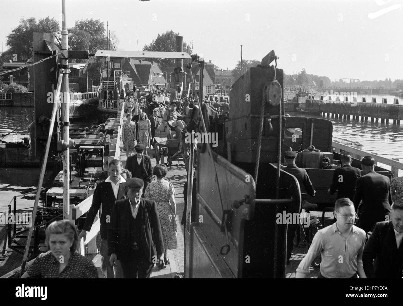 . Huizinga collectie ponten Amsterdam - NIOD - 216352. Nederlands : Foto uit de collectie Huizinga van het NIOD. Een tijdelijke brug van ponten in het Amsterdamse IJ en 1945. En avril tussen augustus lag hier een brug van aaneengeschakelde veerponten, om een verbinding te maken van het centrum van Amsterdam en het Noorden van de stad. Ponten niet konden défaut aan een porte varen brandstof. Veel les habitants staken de brug van pontveren sur om bij boerderijen dix noorden van Amsterdam op zoek naar te gaan eten. De Pontonbrug bestond uit ponten 14,15, 16, 17 fr 18. Menno Huizinga a onderde Banque D'Images