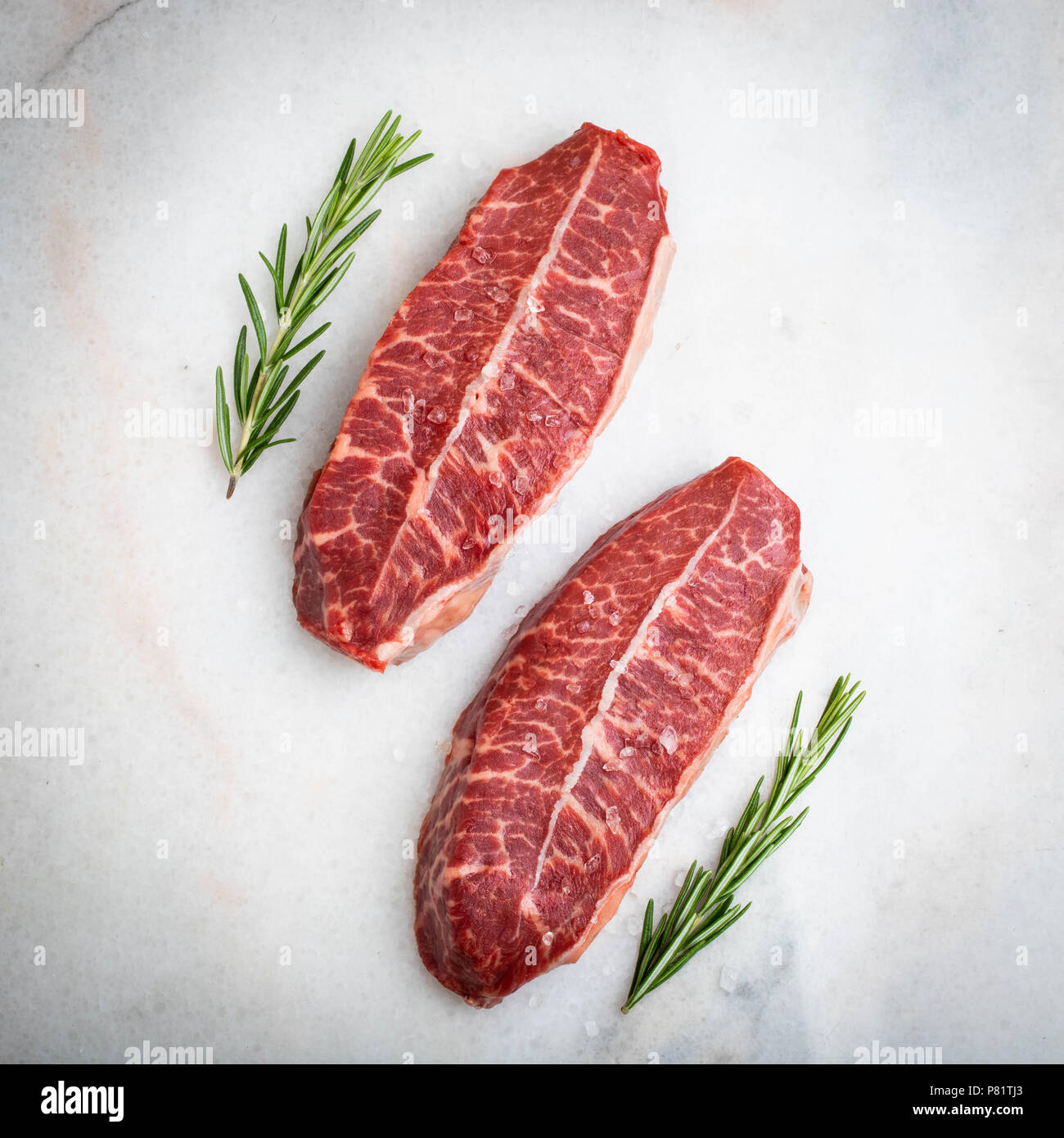 La viande fraîche crue lame supérieure steaks sur fond clair. Vue de dessus Banque D'Images