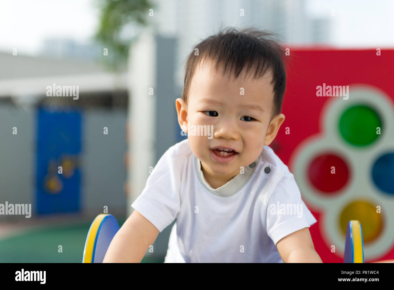 Peu de tout-petit garçon asiatique s'amuser sur l'aire de jeux Banque D'Images