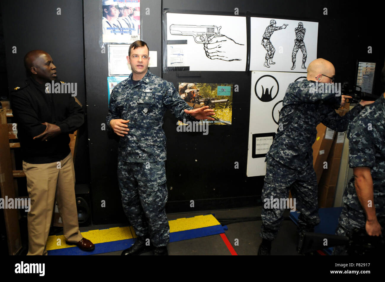 Lacs, Illinois (6 avril 2016) - Force Master Chief (AW/SW/FMF) Karim Cole, debout à gauche, la force Master Chief Naval pour l'éducation et de la formation (NETC), est informé par des artilleurs Mate 1re classe George Martin (EW), GM 'A' instructeur de l'école, centre de l'Unité des systèmes de combat de surface (CSCSU) Grands Lacs, tout en visitant le Fire Arms Training Simulator (graisses) 6 avril. Cole, qui a été nommé à son poste actuel en mars, a visité la Station Navale Grands Lacs (NSGL) Lieux d'apprentissage pour la première fois au cours de sa visite de deux jours ici. Banque D'Images