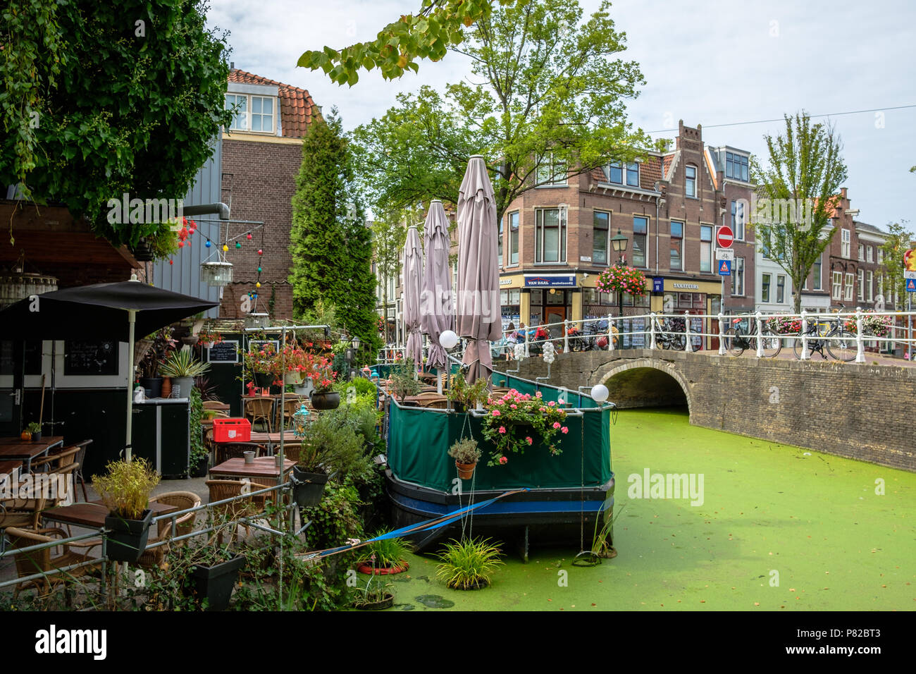 Un restaurant romantique avec des tables sur un bateau dans un canal à Delft, Pays-Bas Banque D'Images