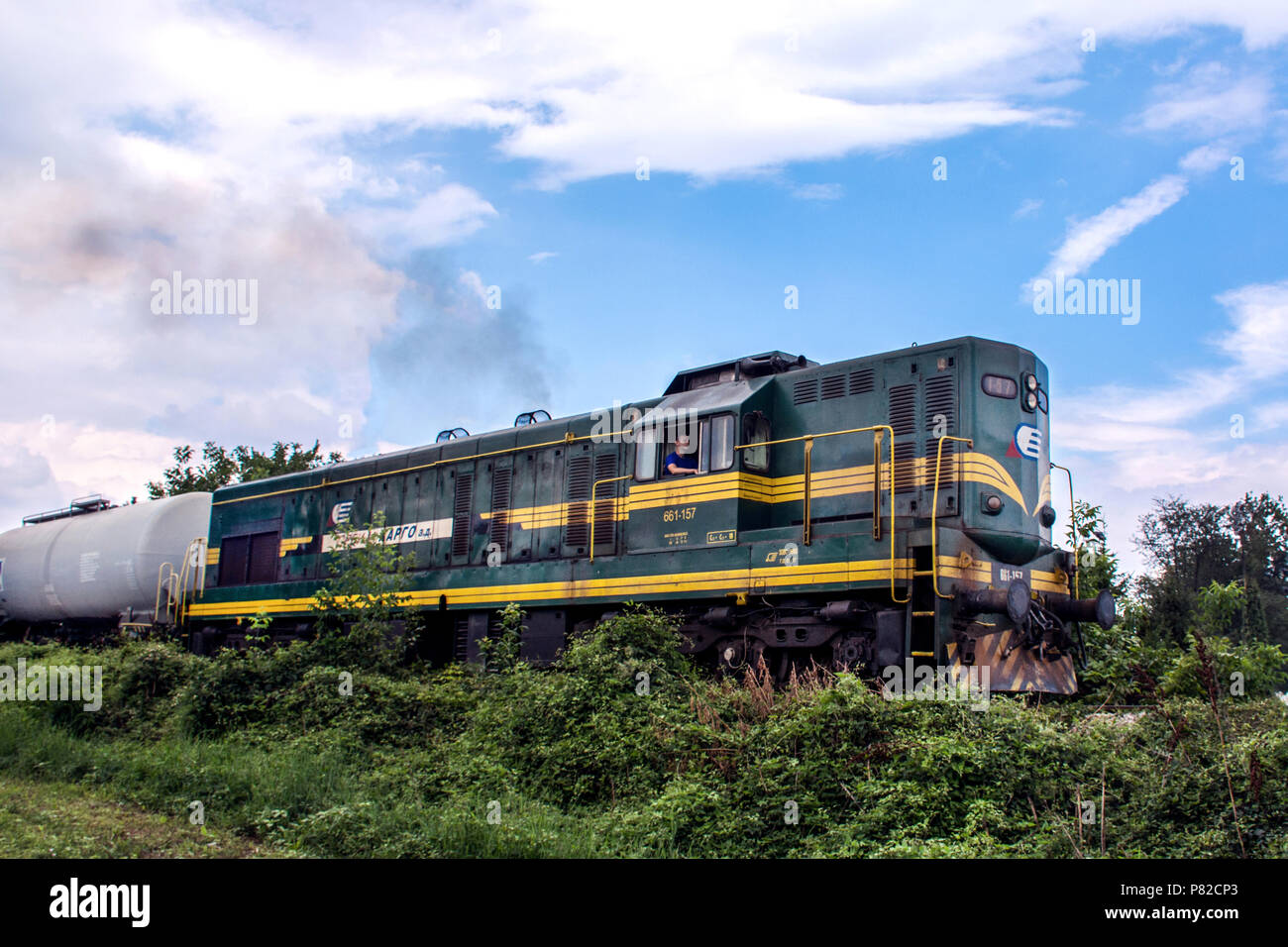 Nis, Serbie - Juillet 08, 2018 : green diesel locomotive sur chemin de fer dans la nature et le bleu ciel nuageux. Train transportant des citernes d'huile Banque D'Images