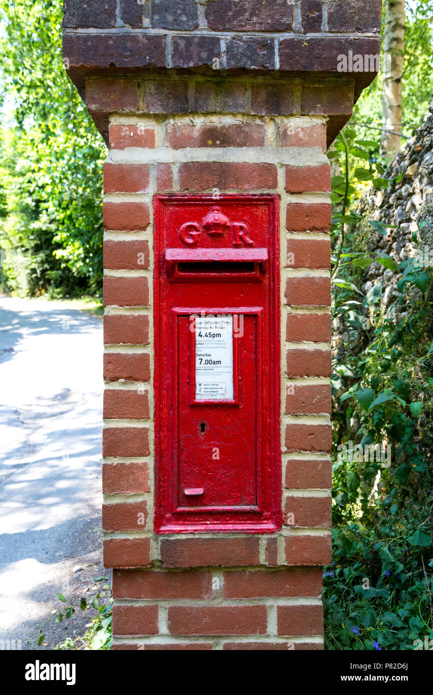 Post box anglais rouge brique dans une colonne avec un monogramme royal de l'époque du roi George V, près de Lewes, UK Banque D'Images