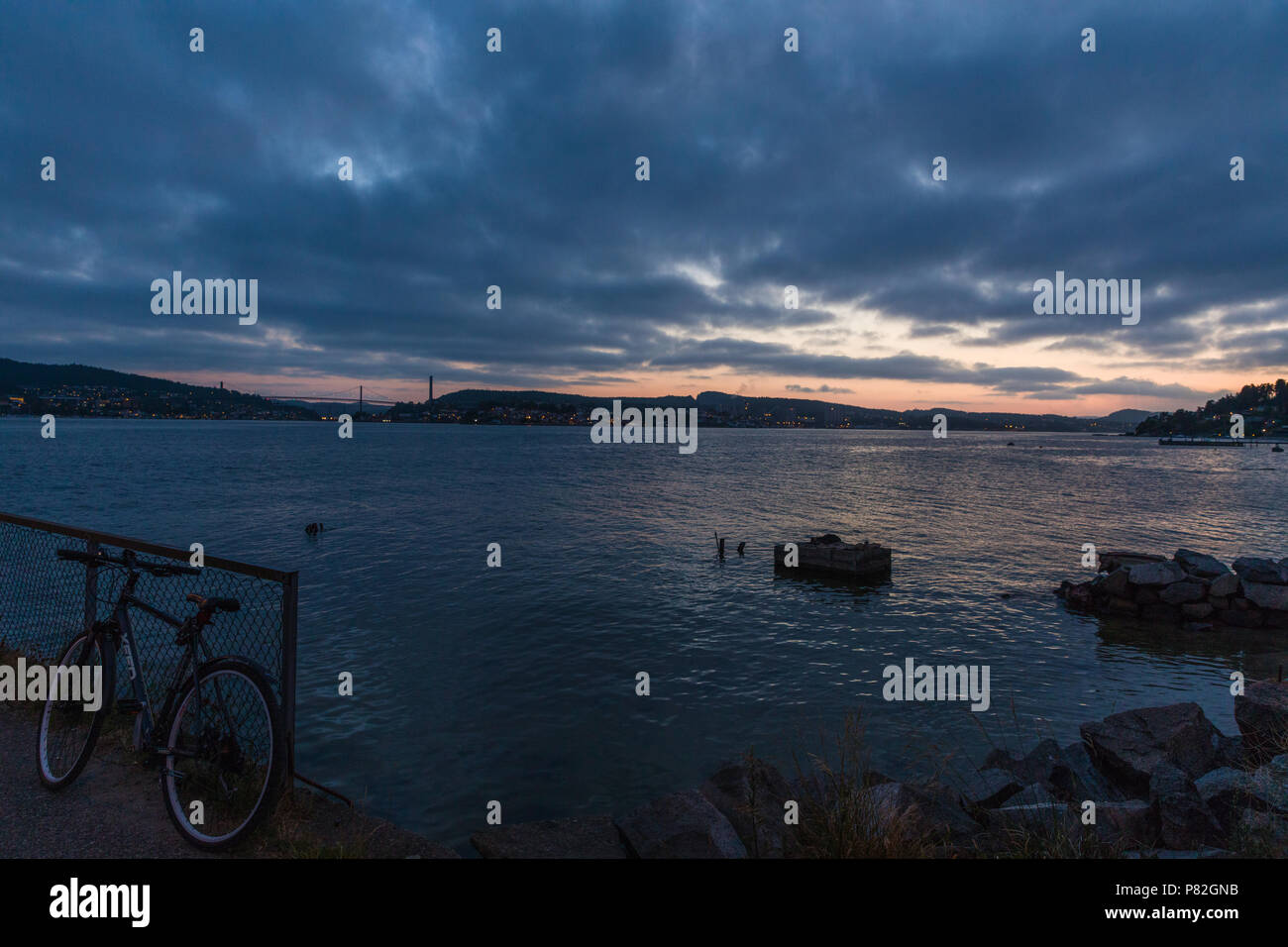 Un vélo appuyé contre une clôture d'un coucher de soleil spectaculaire en arrière-plan Banque D'Images