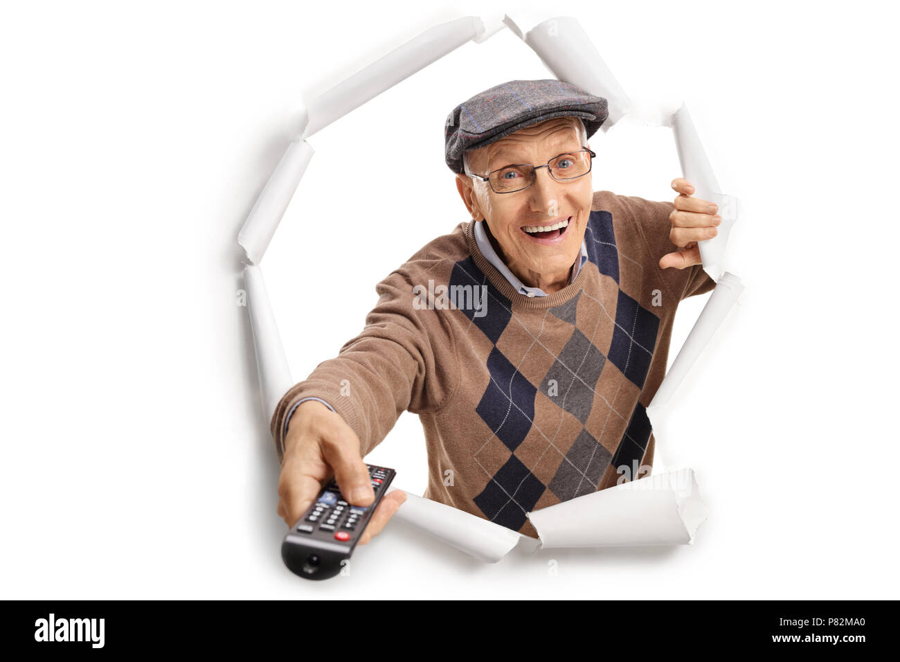 Un homme âgé avec une télécommande Breaking through paper Banque D'Images
