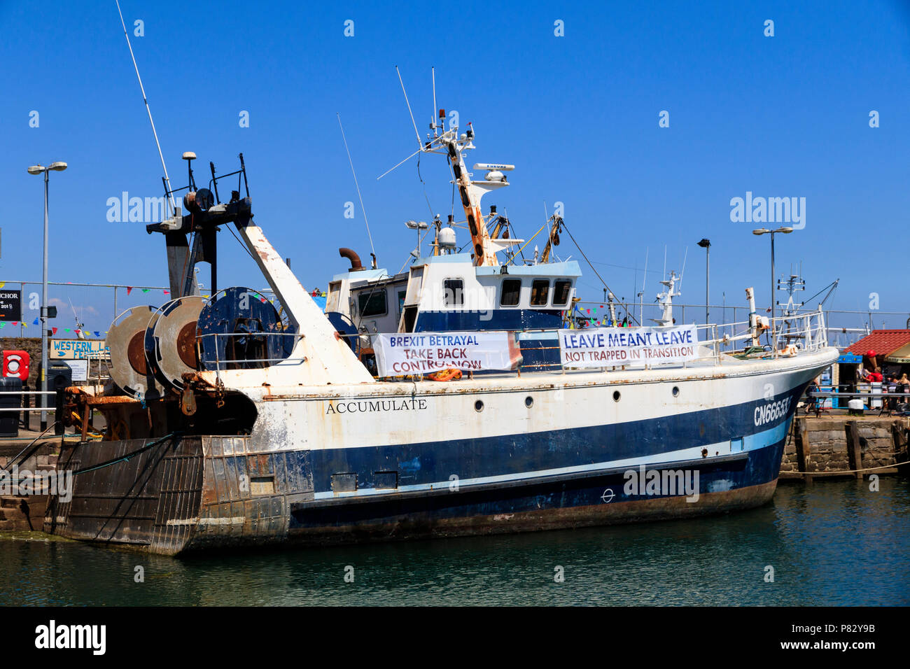 Chalutier en mer s'accumuler l'exécution Brexit banderoles de pêche dans le port de Brixham, Devon, UK Banque D'Images